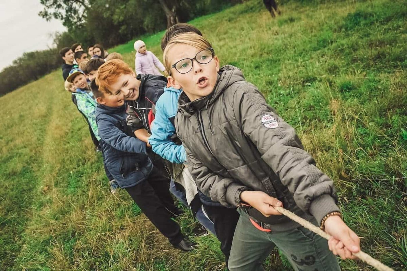 A group of young people playing tug of war outdoors